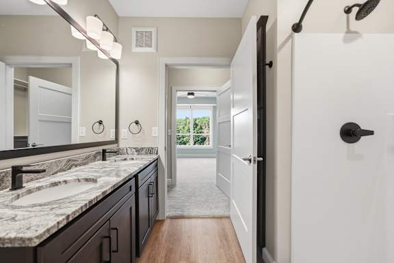 A bathroom with a marble countertop and a large mirror.