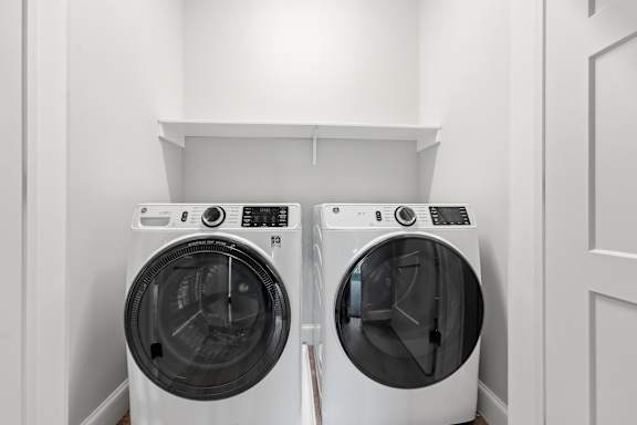 Two front loading washing machines in a laundry room.
