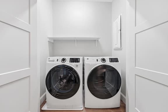 Two front loading washing machines in a laundry room.
