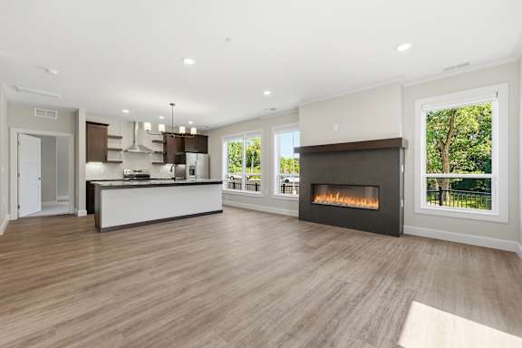 A modern kitchen with a fireplace and a view of the backyard.