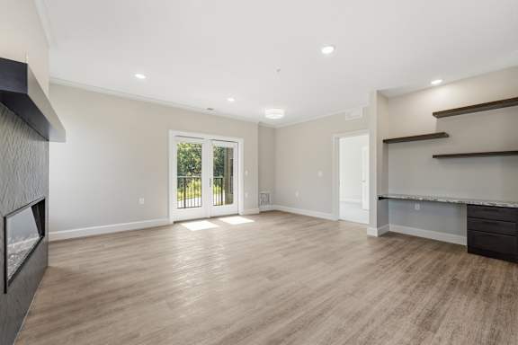 A spacious room with wooden flooring and a large window.