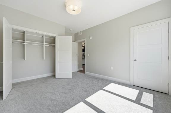 A white room with a rug and a white door.