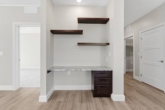 A white room with a built in bed and shelves.