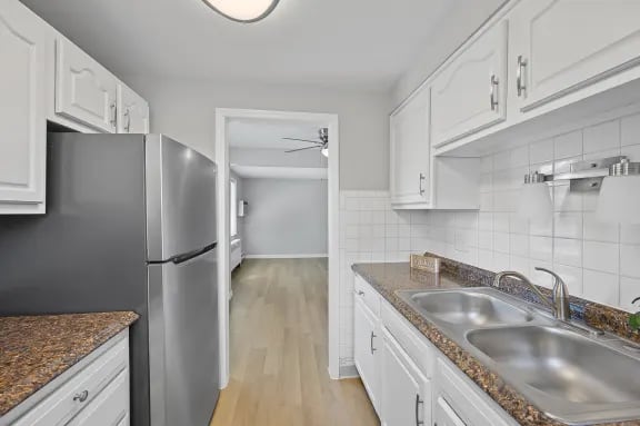 A kitchen with white cabinets and a granite countertop.