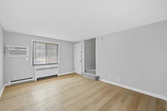 A room with a window and a radiator on the wall.