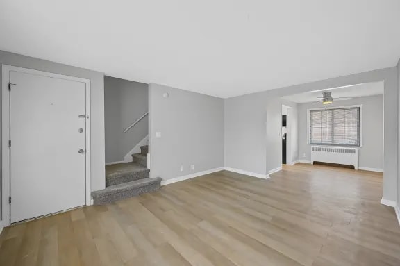 A room with wooden flooring and white walls.