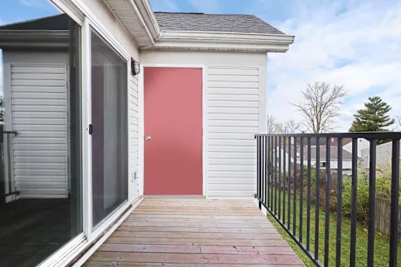 A red door is on the side of a white house at Parkview of Lebanon Apartments, Lebanon 46052