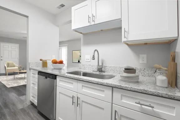 A modern kitchen with white cabinets and a marble countertop at Parkview of Lebanon Apartments, Indiana