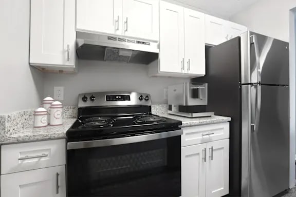 A black and white photo of a kitchen with a stove, oven, microwave, and refrigerator at Parkview of Lebanon Apartments, Lebanon