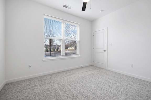 A room with a large window and a carpeted floor.