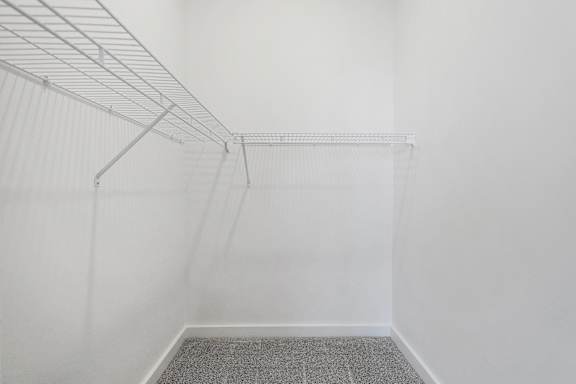 A white wall with a metal shelf attached to it.