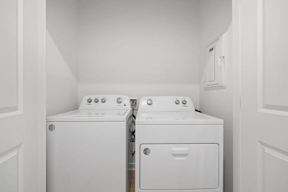 A white washing machine and dryer in a small laundry room.