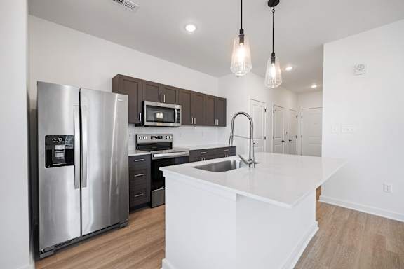 A modern kitchen with a stainless steel refrigerator and a white countertop.