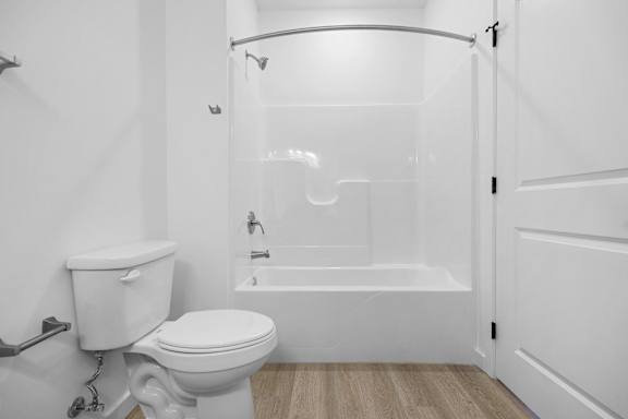 A white toilet is next to a white bathtub in a bathroom.