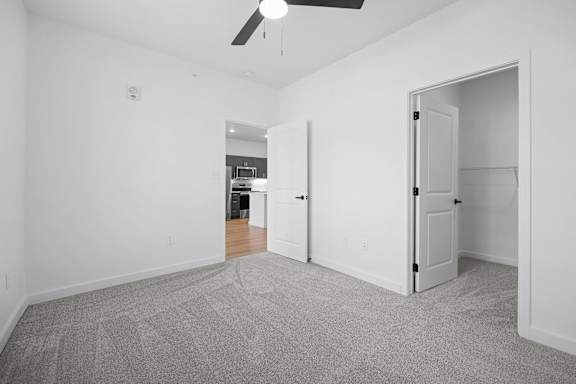 A room with a ceiling fan and two doors.