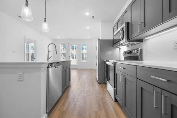 A modern kitchen with dark wood cabinets and stainless steel appliances.