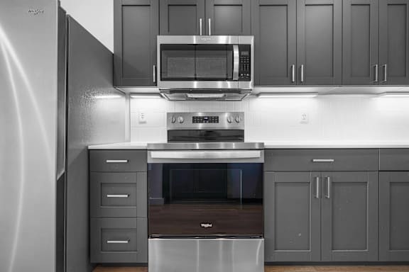 A modern kitchen with a stainless steel refrigerator and a stove top oven.