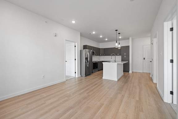 A spacious kitchen with a white island and wooden floors.