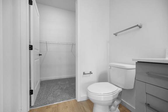 A white toilet in a small bathroom with a white door.