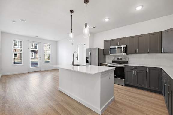 A modern kitchen with a white island and dark brown cabinets.