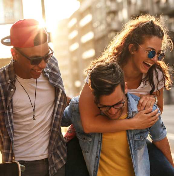 Three friends are walking together on a sunny day.