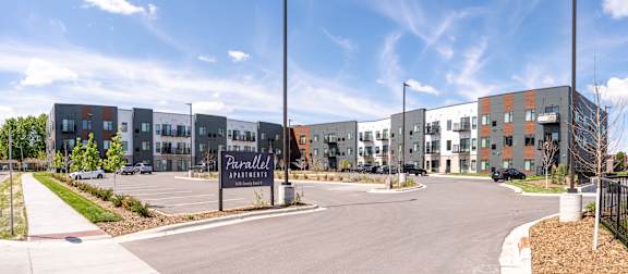 The image shows a modern building complex with a sign that reads