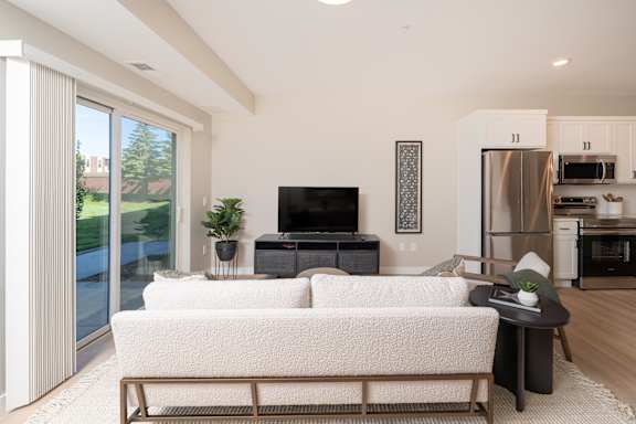 A modern living room with a white couch and a television.