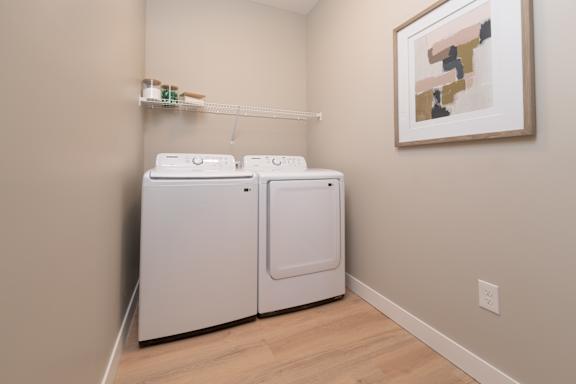Two white washing machines in a laundry room.