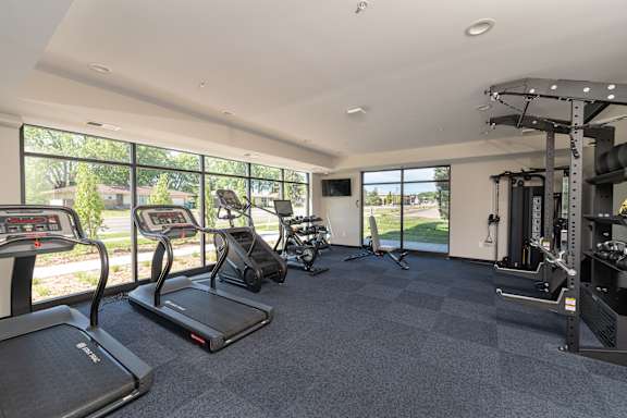 A spacious fitness center with treadmills, elliptical machines, and other exercise equipment.