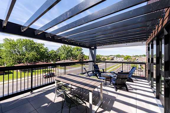 A patio with a table and chairs under a roof.