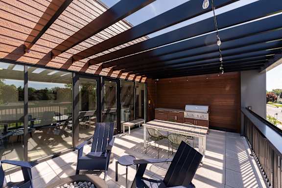 A patio with a table and chairs under a roof.
