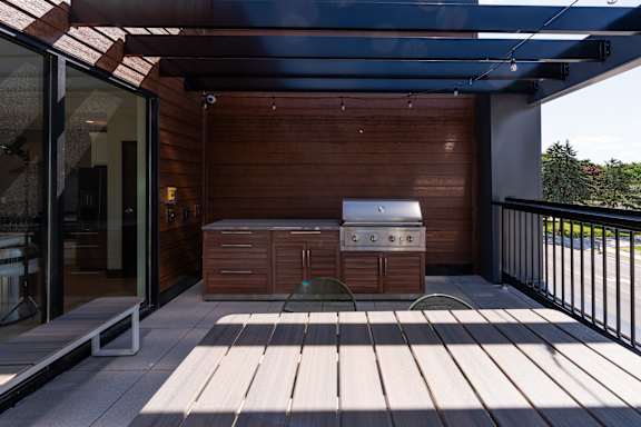 A patio with a table and chairs under a roof.