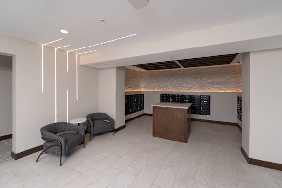 A modern room with a wooden cabinet and two grey chairs.