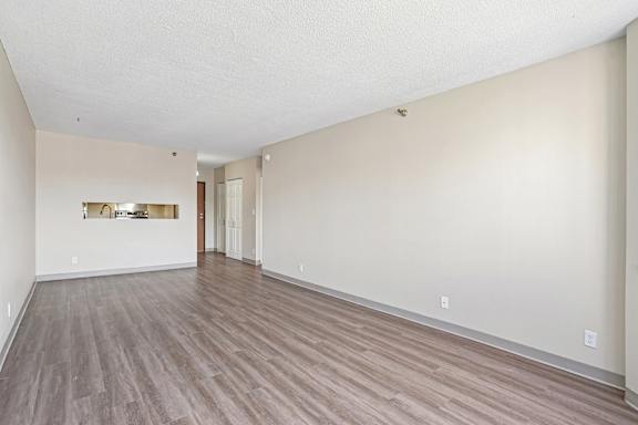 Spacious Irvine Park Towers apartment living room with wood-look flooring and kitchen pass-through
