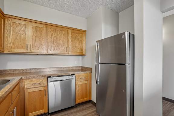 Irvine Park Towers apartment kitchen with wood cabinets, range and countertop workspace