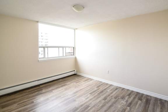 A room with wooden flooring and a window.