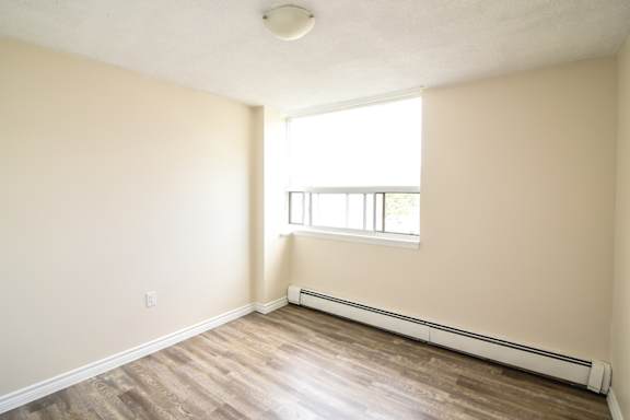 A room with a window and a radiator on the wall.