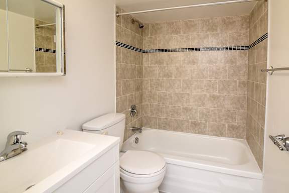 A white toilet sits next to a white sink in a bathroom.