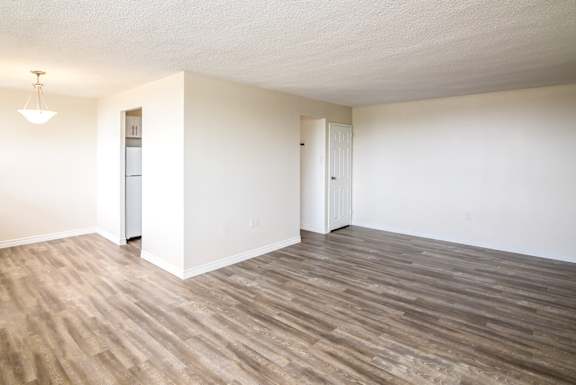 A room with wooden flooring and white walls.