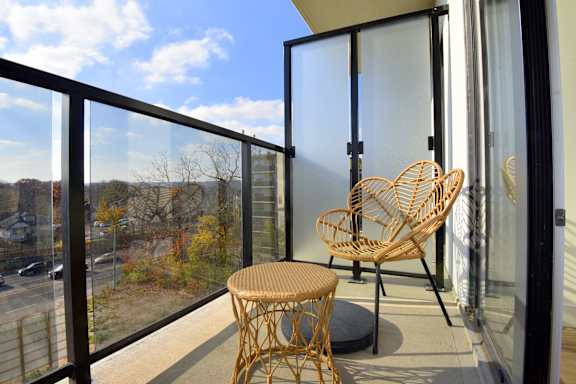 A balcony with a chair and table at Roxy Apartments, Ontario, L8H 0B7