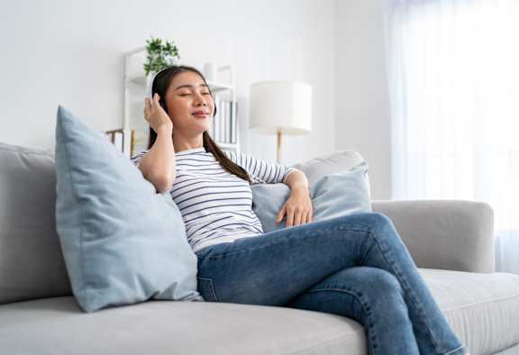A woman is sitting on a couch at The Maverick Apartments, Ontario