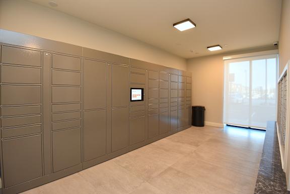 A room with a wall of lockers and a monitor on the wall at Roxy Apartments, Ontario