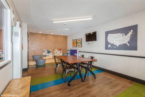 A room with a table and chairs and a map of the United States on the wall.