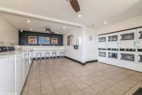 A kitchen with white appliances and a fan on the ceiling.