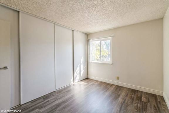 A room with a window and a wooden floor.