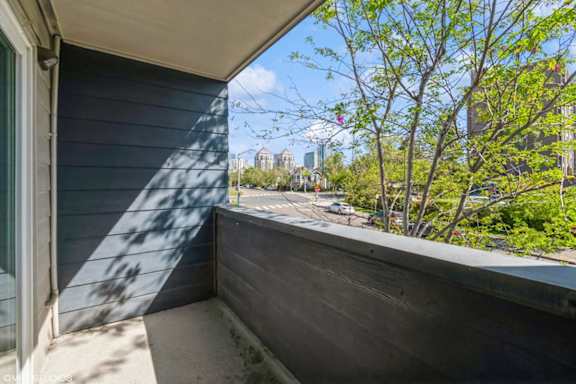 A balcony with a view of a cityscape and trees.