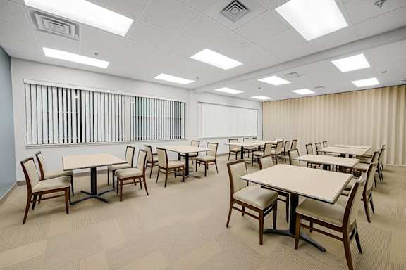 A conference room with multiple tables and chairs.