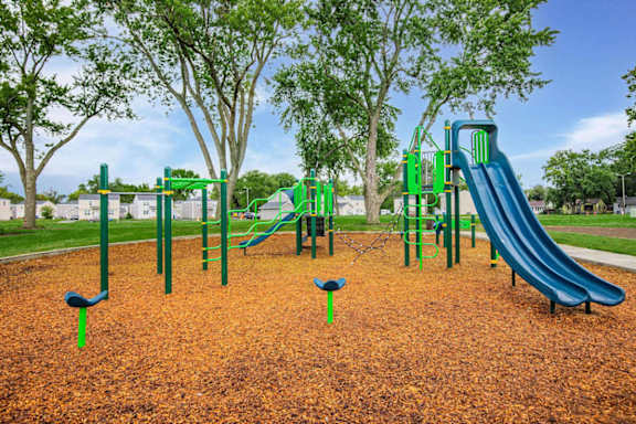 A playground with a green slide and a blue slide.