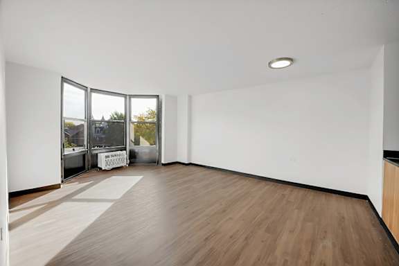 A room with a white wall and a wooden floor.