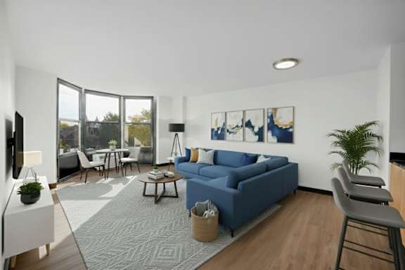 A living room with a blue couch and a grey rug.
